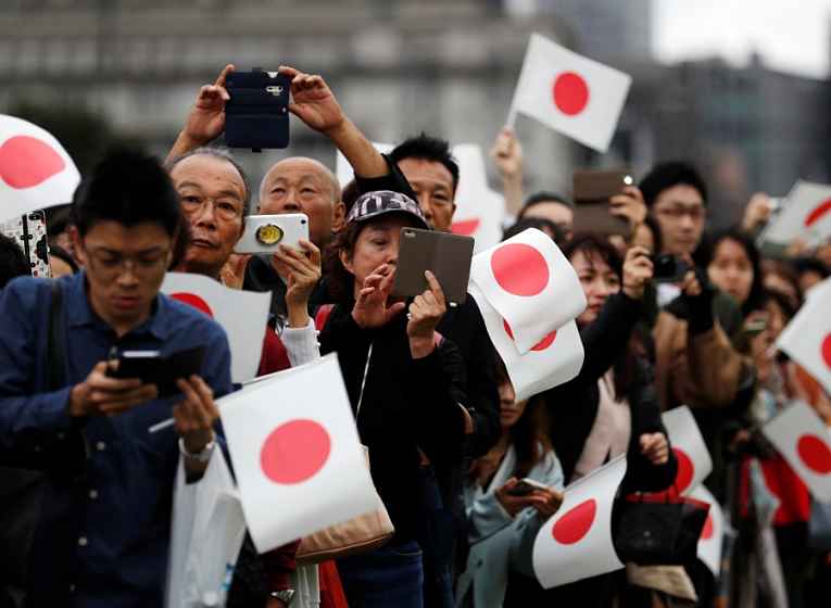 População nas ruas com bandeiras do Japão