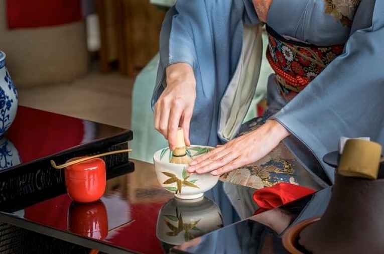 Mulher misturando matcha seco na xícara