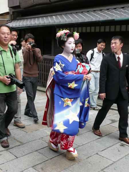 geisha andando com pessoas em sua volta